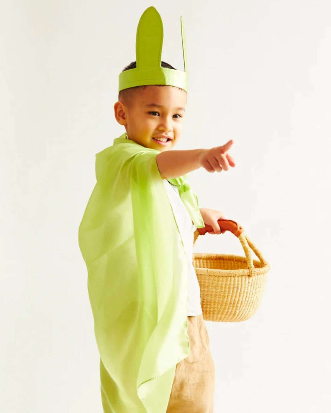 Grønn lekesilke fra Sarahs silks benyttes som kappe av et barn. På hode har barnet et hårbånd med kaninører i samme grønnfarge som lekesilken. 